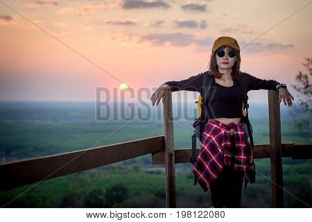 Tourist Young Woman Stand On The Moutain Watching The Beautiful Sunset.