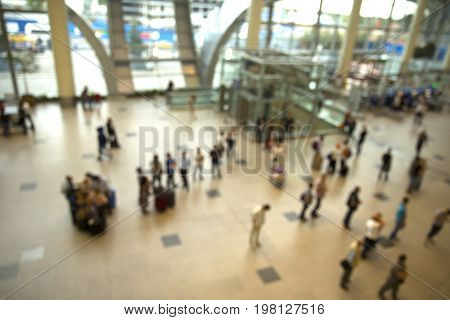 Airport. Blurred people in the main lobby closed to fly announced desk. They are in big city airport.