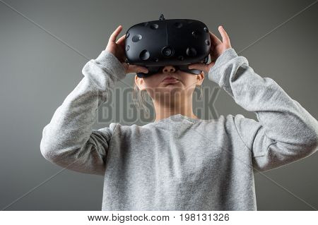 Girl Wearing Virtual Reality Goggles Standing On Grey Background. Vr Glasses. 360 Degrees. Virtual R