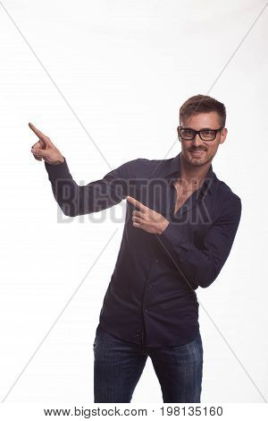Young jocular man portrait of a confident businessman showing by hands on a gray background. Ideal for banners, registration forms, presentation, landings, presenting concept.