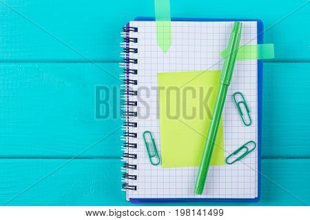 green calculator with a paper sticker on a blue background top view