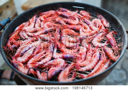 Fresh shrimps Gambos is preparing on grill outdoors