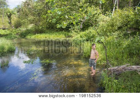 Summer is a bright sunny day on the river bank is a boy.