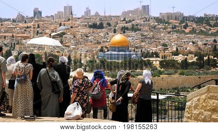 Jerusalem, Israel - May 25, 2017: The Christian orthodox guide shows the Jerusalem Old City view to the pilgrims and tourists from the Mount of Olives. Famous Holy Land place and fantastic city view.