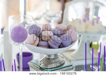 Wedding macaroni purple on a plate. Sweet table