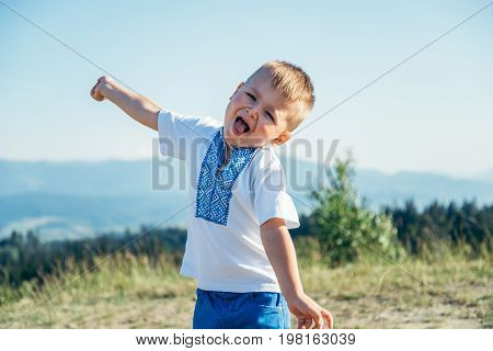 little boy playing on the top of the mountain with beautifull view on background