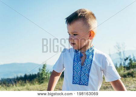 little boy playing on the top of the mountain with beautifull view on background