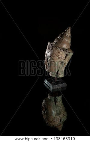 Spiritual enlightenment. Traditional buddha head statue. Museum quality buddhist statuette on display against black background with copy space.