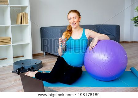 A portrait of a pregnant woman drinking water