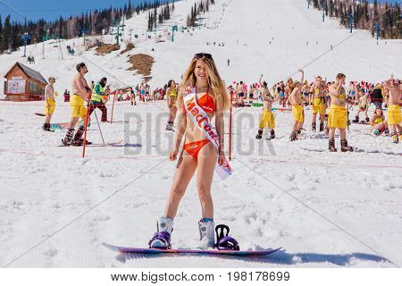 Young Happy Pretty Women On A Snowboard In Colorful Bikini.