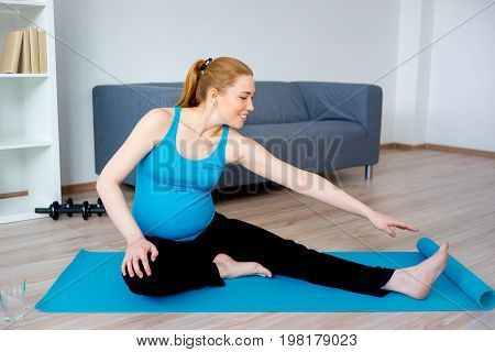 Pregnant woman doing pre-natal exercises at home
