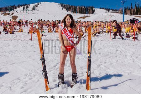 Sheregesh, Kemerovo region, Russia - April 22, 2017: Grelka Fest is a sports and entertainment activity for ski and snowboard riders in bikini in Russia, Sheregesh. Young happy pretty women with mountain ski in red bikini.