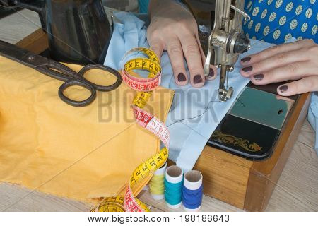 processes of sewing on the sewing machine sew women's hands sewing machine. sewing machine and female scissors