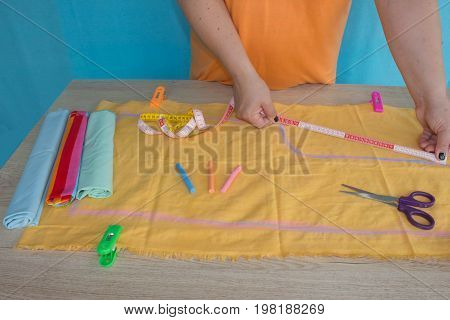 Tailor woman working in his tailor shop Tailoring. A tailor is laying out a dress/Sewing layout