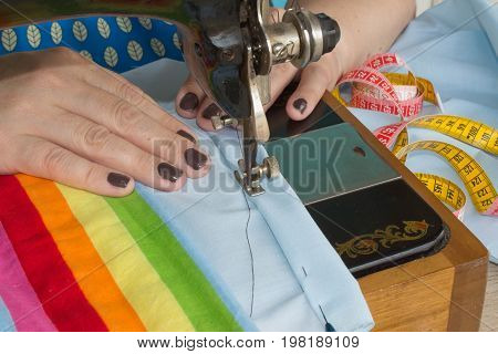 processes of sewing on the sewing machine sew women's hands sewing machine. Female tailor threading leather material on sewing machine
