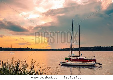 Summer evening landscape. Boats on the lake and colorful sky.