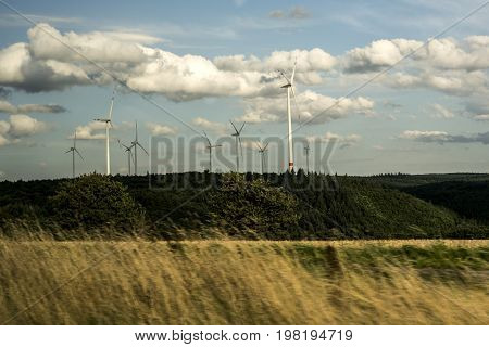 Wind energy generator Windmills cloudy sky in Germany Eifel