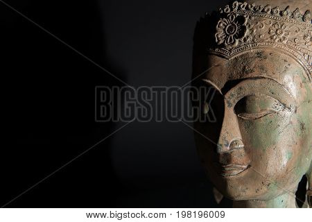 Spiritual enlightenment. Buddha statue head with copy space. Zen buddhism in the spotlight.