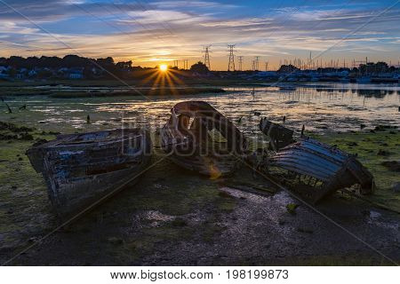 Derelict boats in the backwaters of Holes Bay Poole Harbour at low tide