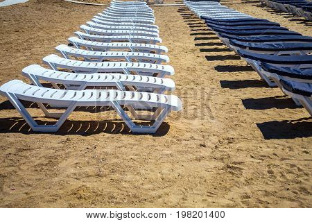 Row of beach beds on an empty beach selective focus.