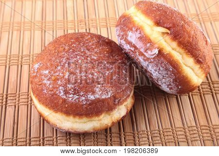 Homemade Doughnuts with Jelly filled and powdered sugar on Bamboo tablecloth. Selective focus