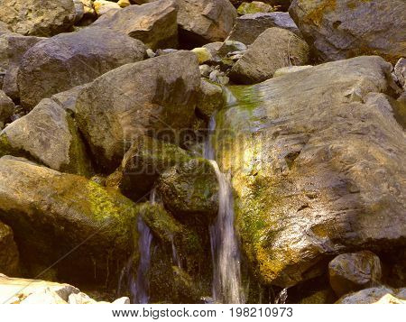 Water coming out of the rocks from a spring closeup.