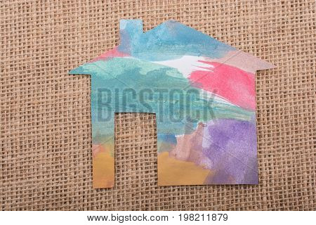 Hand Holding A Paper House On Canvas