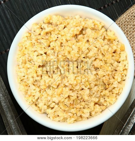Cracked Freekeh in bowl at table.