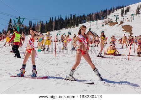 Group Of Young Happy Pretty Women On A Snowboard In Colorful Bikini With Flags.