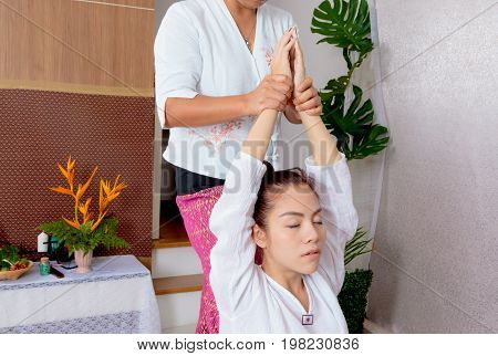 Asian Woman Getting Traditional Thai Stretching Massage By Therapist