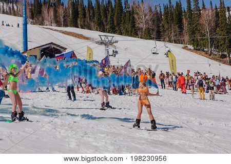 Group Of Young Happy Pretty Women On A Snowboard In Colorful Bikini With Flags.