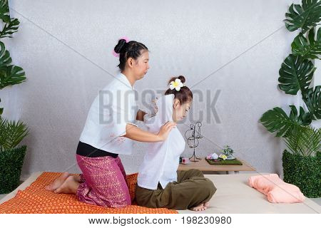 Asian Woman Getting Traditional Thai Stretching Massage By Therapist