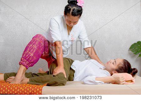Asian Woman Getting Traditional Thai Stretching Massage By Therapist