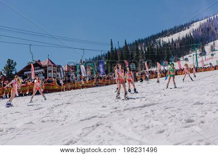 Sheregesh, Kemerovo region, Russia - April 22, 2017: Grelka Fest is a sports and entertainment activity for ski and snowboard riders in bikini. Group of young women on a snowboard in colorful bikini.