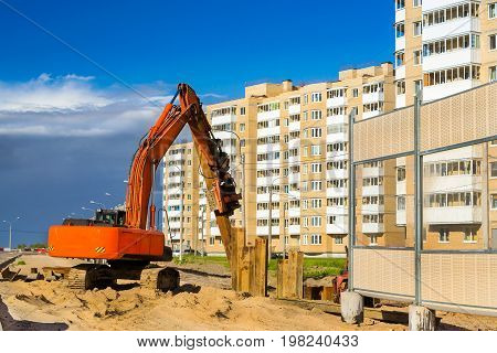 Crawler Excavator to hammer a steel piles into ground. Construction of high-speed bypass road around Krasnoe Selo Saint Petersburg. Heavy machine equipment for excavation works in industry. Russia