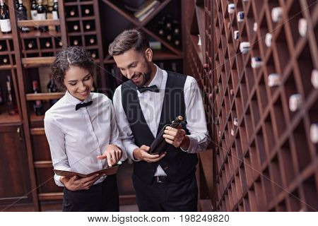 Sommeliers Choosing Wine In Cellar