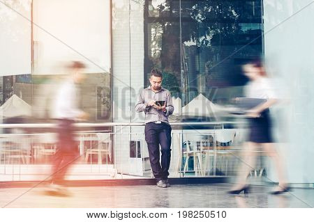 Businessman Using A Digital Tablet Office Outdoors And Blurred People Walking In Front Of Modern Off