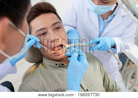 Young man having his tophus removed at dentist