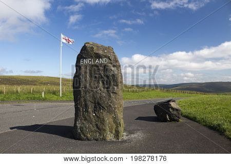 English flag rock with England painted on it and information board marking the Scottish - English Border Northumberland United Kingdom