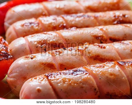 Close up view of chicken homemade sausages. Grilled sausages and grilled vegetables. Copy space.