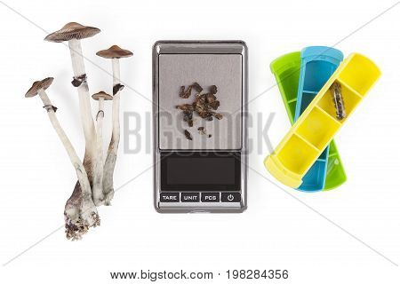 Magic mushrooms medicine microdosing pillbox digital scale isolated on white background from above. Psychedelic psilocybin medicine natural remedy.