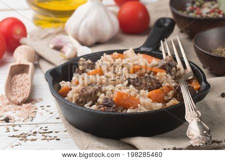 Devzira pilaf with lamb, onions, carrots and spices (cumin, coriander, pepper). Traditional dishes of Uzbek cuisine. Selective focus