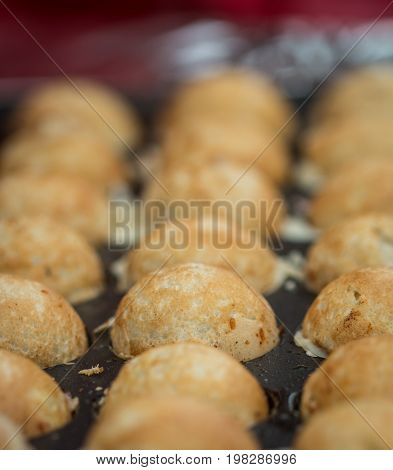Takoyaki with octopus. The process of making the popular Japanese snacks. Selective focus