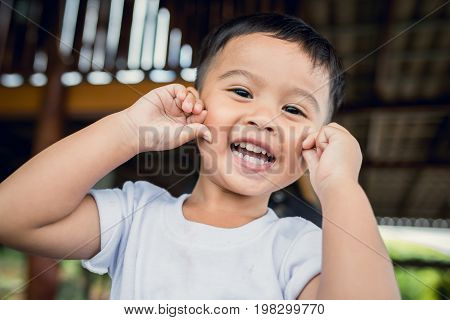 Portrait of happy Asian child toddler boy smiling close up looking at camera. Education Concept.