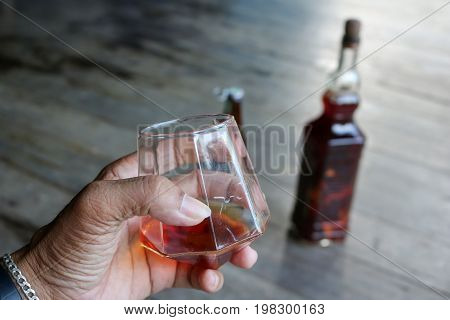 Local whiskey in a glass with bottle of herbal liquor in Thailand.