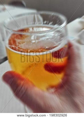 blur picture of a beer glass in man's hand to simulate overdrink