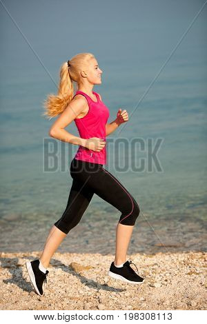 jogging in th beach - woman runns near sea on early summer morning