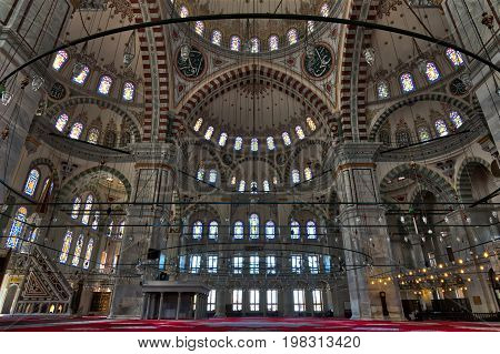 Istanbul Turkey - April 25 2017: Interior of Fatih Mosque a public Ottoman mosque in Fatih district with a huge decorated domes & many colored stained glass windows