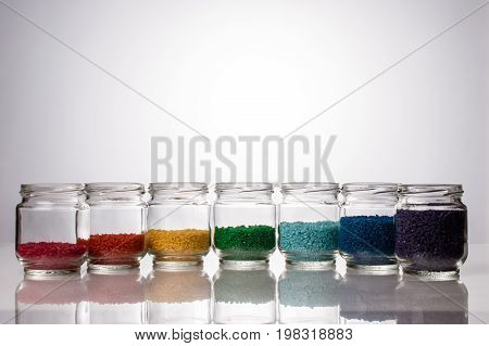 colored rice in glass jars is by colors of the rainbow