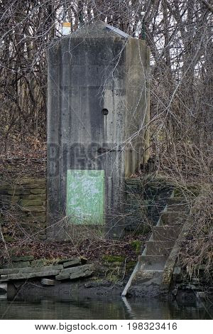 SHOREWOOD, ILLINOIS / UNITED STATES - DECEMBER 6, 2015: An old concrete bunker stands on the bank of the Du Page River in the Hammel Woods Forest Preserve.